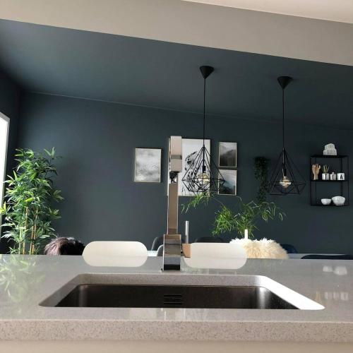 a kitchen with a sink and a black wall at Family house in Ålgård in Ålgård