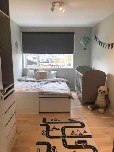 a small bedroom with a bed and a teddy bear at Family house in Ålgård in Ålgård
