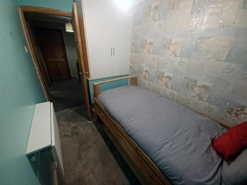 a small bed in a room with a wall at The Rushdon in Grays Thurrock