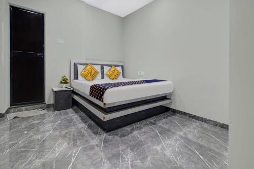 a bedroom with a bed with yellow and black pillows at Hotel O The VNP Inn in Sakardarā