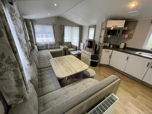 a living room with a couch and a table at 3 Bedroom Caravan MC37, Shanklin, Isle of Wight in Shanklin