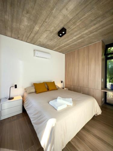 a bedroom with a large bed with a wooden ceiling at Terrazas del Bosque in La Pedrera