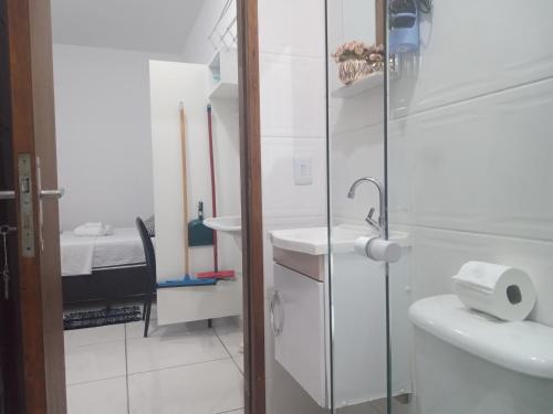 a white bathroom with a toilet and a sink at Loft7 Garagem Wifi próximo Aparecida e indústrias in Pindamonhangaba
