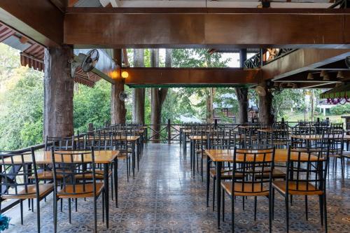 una fila di tavoli e sedie in un ristorante di Pung-Waan Resort a Sai Yok