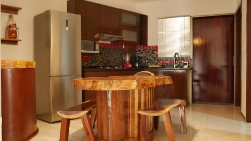 a kitchen with a wooden table and a refrigerator at Depas Colinas del Valle in Tepic