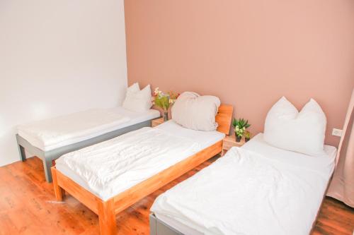 two beds in a room with white sheets and pillows at GMA Apartment B12 in Lahr
