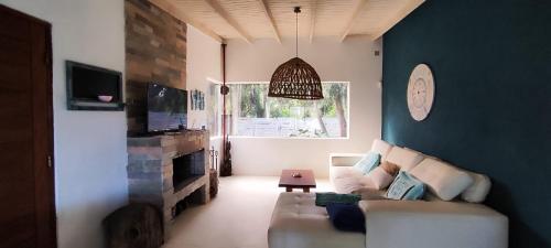 Una sala de estar con un sofá y un reloj en la pared. en Bosque del Este II, en Balneario Buenos Aires
