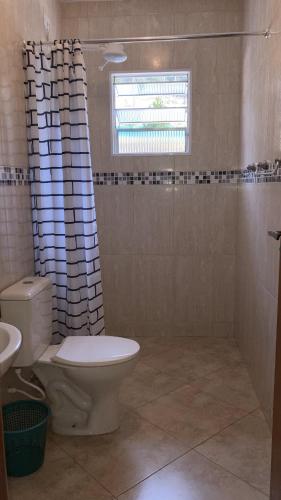 a bathroom with a toilet and a shower curtain at Refúgio Vista da Mata in Mairiporã
