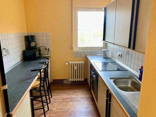 a kitchen with a sink and a counter with stools at GMA Apartment B12 in Lahr