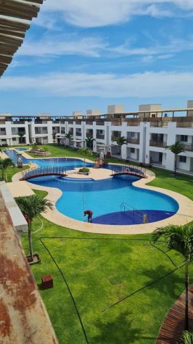a large swimming pool in a courtyard of a building at Canoa Breeze - Apartment Roof Top in Canoa Quebrada