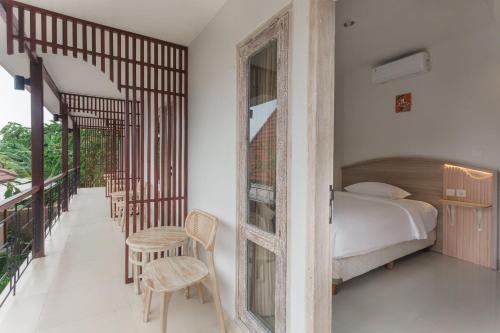 a bedroom with a bed and a table and chairs at Iconic Lodge Uluwatu in Uluwatu
