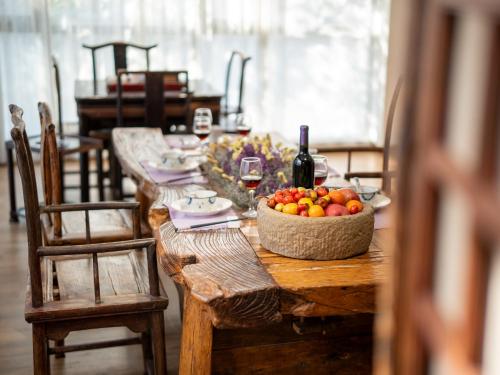 a table with a bowl of fruit and a bottle of wine at PuYuan Laoyangfang Huayuan GuestHouse in Xi'an
