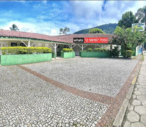 a building with a sign in front of it at Pousada Caraguatatuba in Caraguatatuba