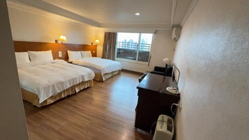 a hotel room with two beds and a window at Royal Business Hotel (Self Check-in) in Hsinchu City