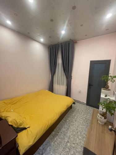 ein Schlafzimmer mit einem gelben Bett und einem Tisch in der Unterkunft Thương Thương Đà Lạt 2 in Xuan An