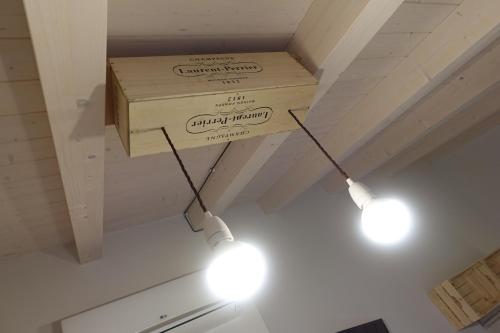 two lights hanging from a ceiling with a box at Rooms Maison 3 Magnoni in Trieste