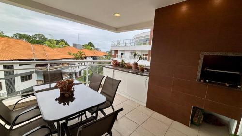 a balcony with a table and chairs and a fireplace at Flat 3 suites frente mar in Florianópolis