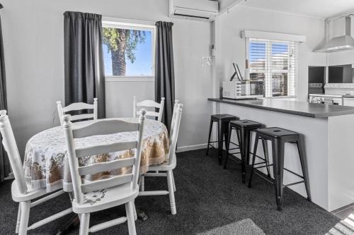 a kitchen with a table and chairs in a room at Holiday Home on Iconic Tay St Location 3 bedrooms in Mount Maunganui