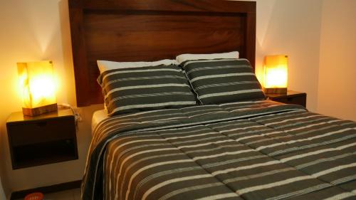 a bedroom with a large bed with two lamps at Depas Colinas del Valle in Tepic