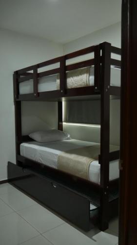 a wooden bunk bed with a bed in a room at Depas Colinas del Valle in Tepic
