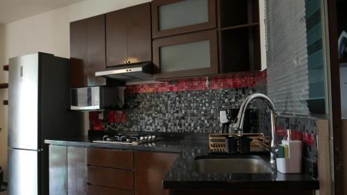 a kitchen with a sink and a refrigerator at Depas Colinas del Valle in Tepic