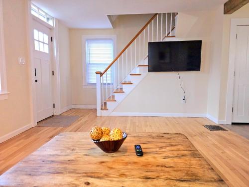 a living room with a bowl of fruit on a table at Cozy Coastal Cottage in New London