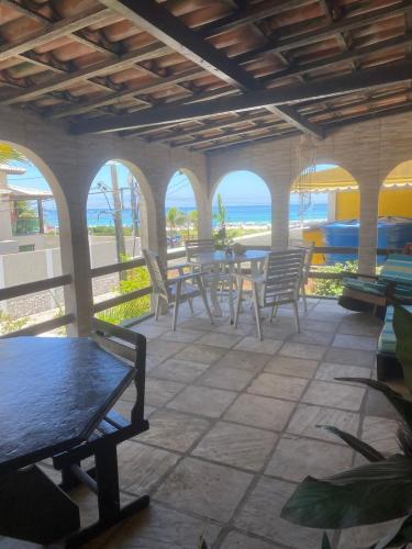 アハイアウ・ド・カボにあるCasa na Praia Grandeのテーブルと椅子と海のあるパティオ