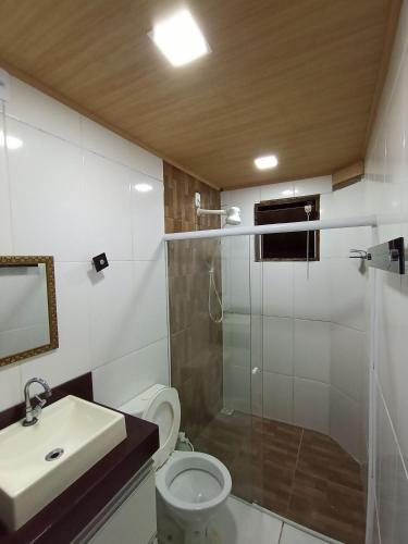 a bathroom with a shower and a toilet and a sink at Casa Temporada peterle Iriri in Iriri