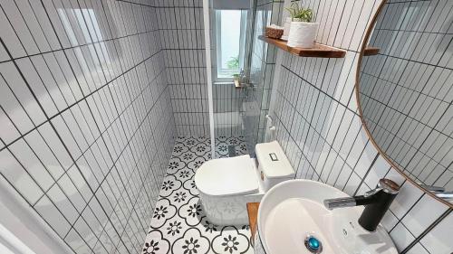a bathroom with a toilet and a sink and a mirror at Homestay NAD nguyên căn tại Phan Thiết in Ấp Sung Xuân