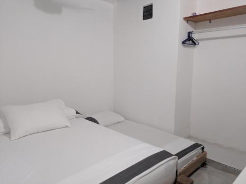 a white bed in a white room with white walls at Apartamento Confort - Planta Baja in Arboletes
