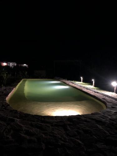 a green pool of water on the beach at night at Caliu Earthship Ecolodge in Colonia del Sacramento
