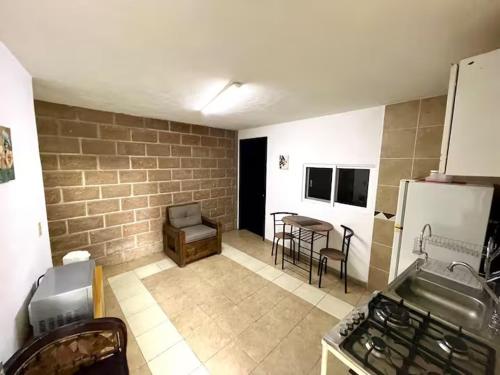 a kitchen with a brick wall and a kitchen with a stove at Edificio Rosedal 2 in Oaxtepec