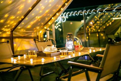 a table with candles and a bottle on it with lights at 我们的小院-不期而遇 in Zhoushan