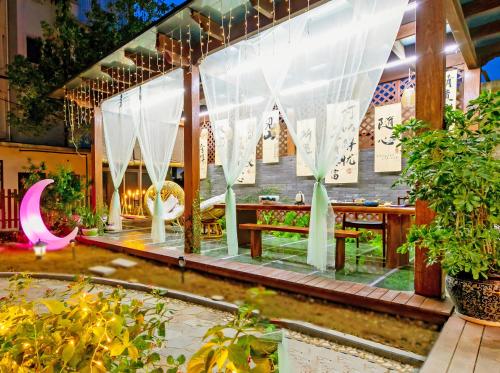 a greenhouse with a table and chairs and plants at 我们的小院-不期而遇 in Zhoushan