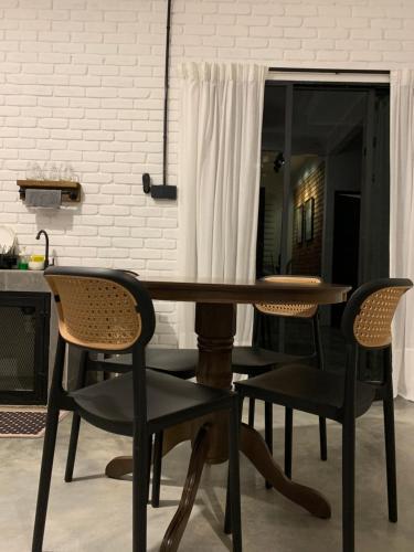a dining room table with two chairs and a mirror at RumaTisa in Teluk Intan