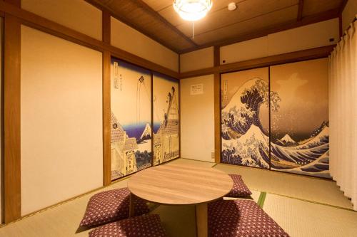 a room with a table and chairs and paintings at Paradiso青戸 in Tokyo