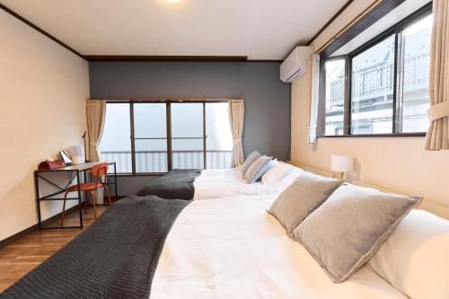 a bedroom with two beds and a large window at Paradiso青戸 in Tokyo