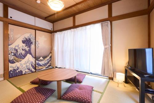 a room with a table and a tv in a room at Paradiso青戸 in Tokyo