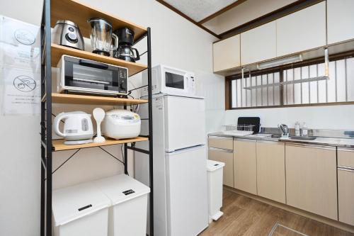 a kitchen with white appliances and a refrigerator at Paradiso青戸 in Tokyo