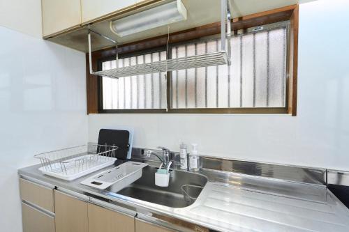 a kitchen with a sink and a window at Paradiso青戸 in Tokyo