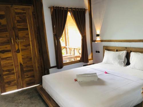 Postel nebo postele na pokoji v ubytování Umah Kayu 1-Menjangan homestay