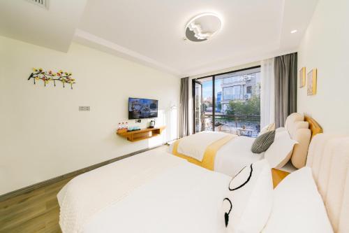 a hotel room with two beds and a window at 我们的小院-不期而遇 in Zhoushan