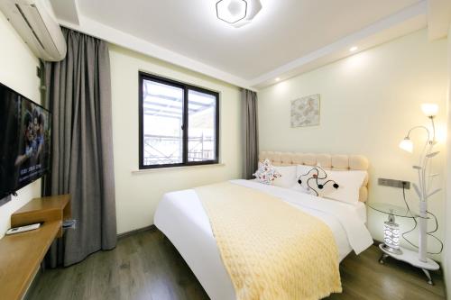 a hotel room with a bed and a television at 我们的小院-不期而遇 in Zhoushan