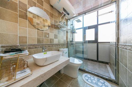 a bathroom with a sink and a toilet and a window at 我们的小院-不期而遇 in Zhoushan
