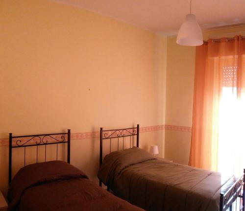 シラクーサにあるVilla Lucia Isolaのベッドルーム1室(ベッド2台、窓付)