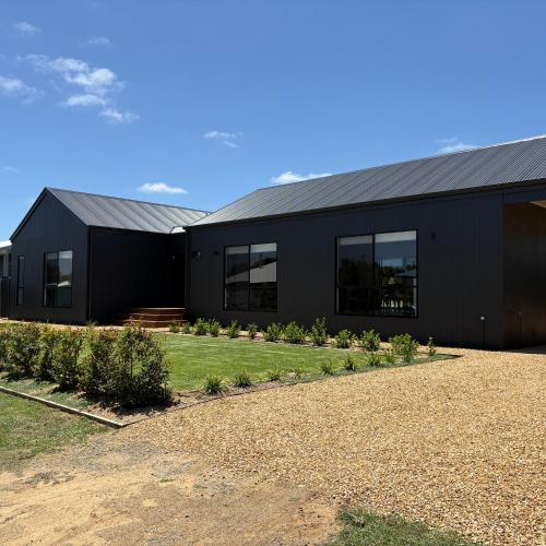 a black building with a driveway in front of it at Goolwa Beach Pavilion in Goolwa South