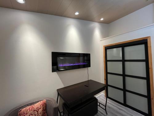 a room with a table and a tv on the wall at Banff Woods lodge in Canmore