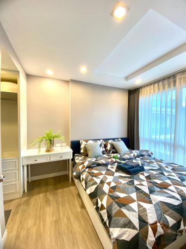 a bedroom with a large bed and a window at Lucky Lucky Chill in Chon Buri