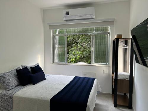 a bedroom with a bed and a window at Studio Completo com Vista no Catete in Rio de Janeiro