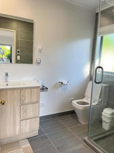 a bathroom with a toilet and a sink and a shower at Family Retreat with Playground Views in East Tamaki in Auckland